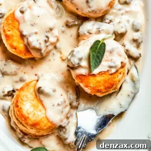 Sausage and gravy biscuits served on an oval white serving dish.