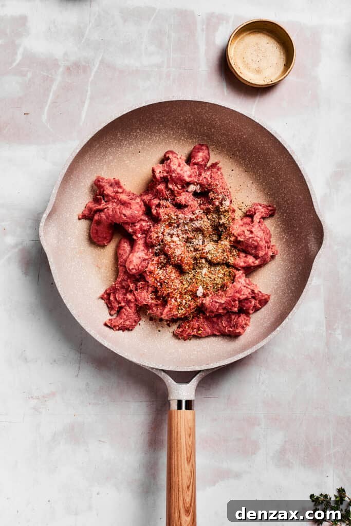 Sausage and herbs are added to a pan.