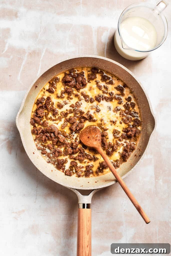 The sausage is stirred in the pan.