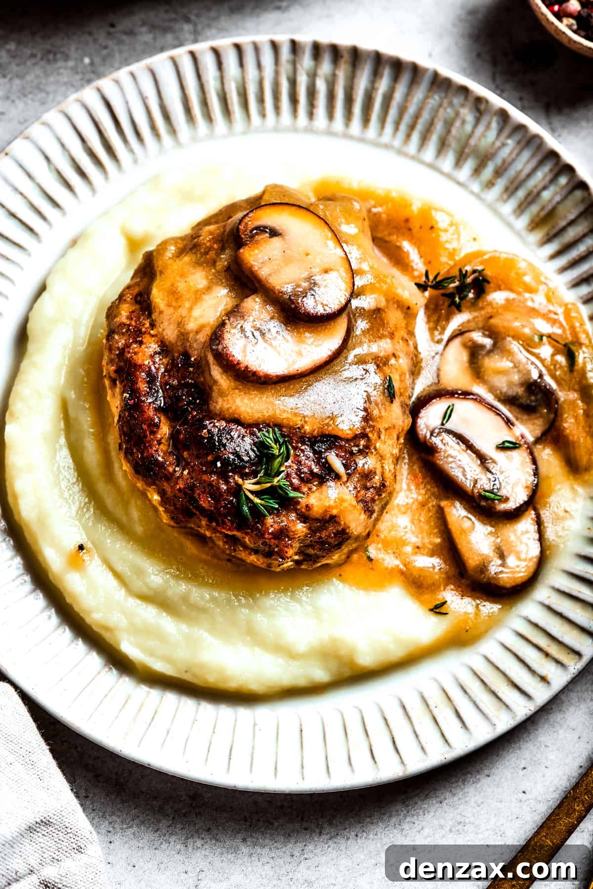 A serving of chopped steak served over mashed potatoes.
