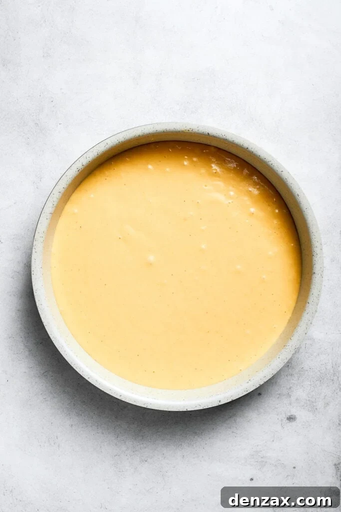 Pour batter over pineapple rings. The batter is added on top of the pineapple and cherries.