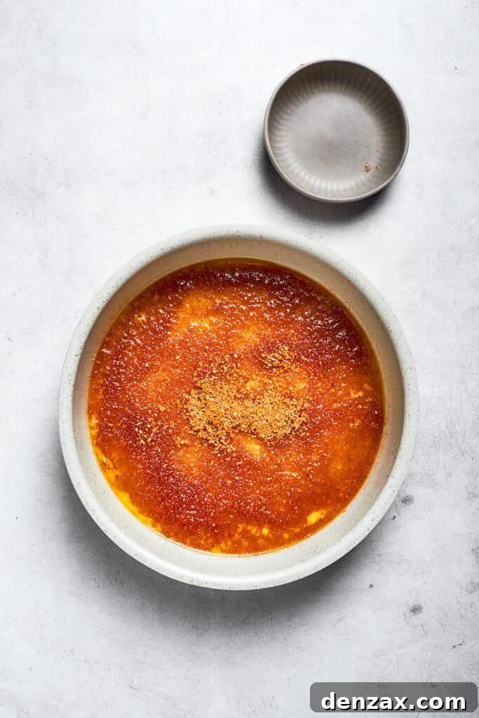 Combine the melted butter and brown sugar in a round cake pan. Brown sugar is swirled into the butter.