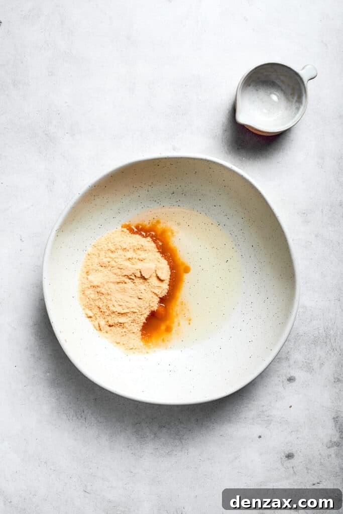 Combine oil and sugar. Oil and sugar are added to a bowl.
