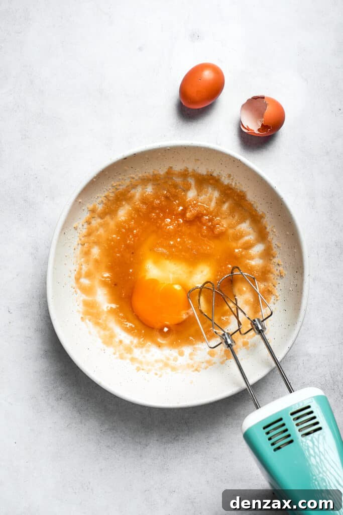 Mix the eggs into the oil mixture. A hand mixer beats in the eggs.