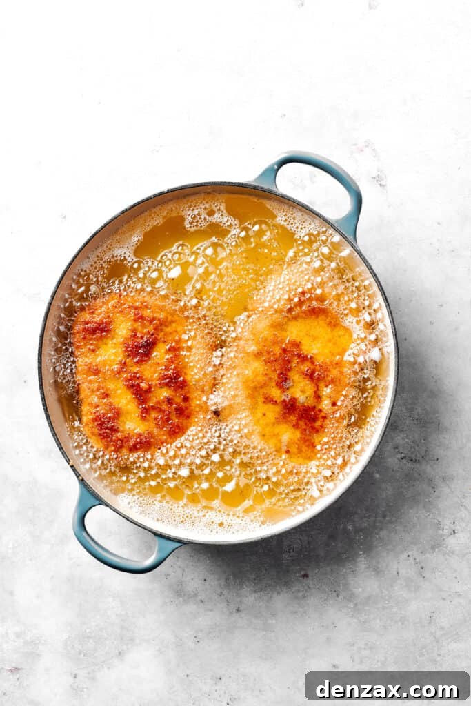 Pork cutlets frying in oil.