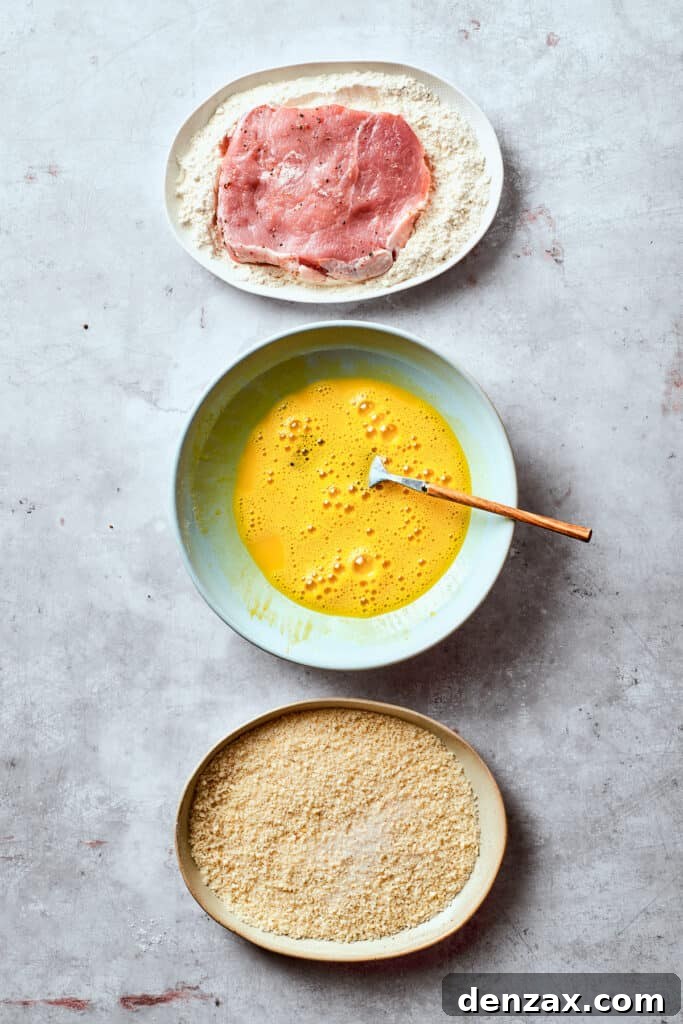 Breading station set up with a bowl of beaten eggs, a bowl of flour, and a bowl of panko.