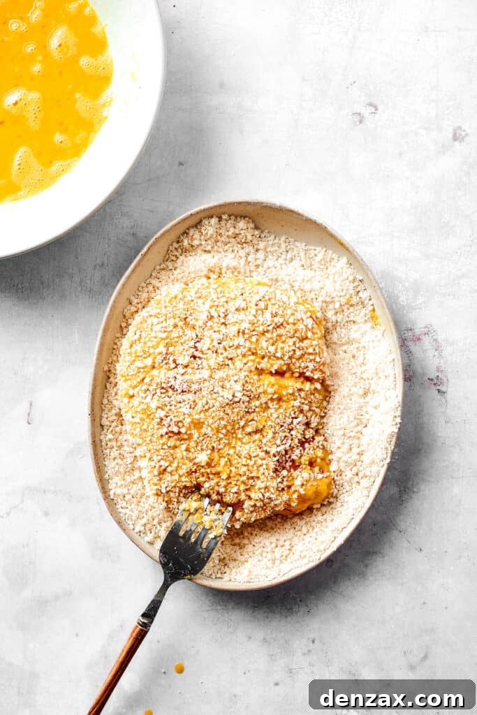 Dredging pork cutlets in breadcrumbs.