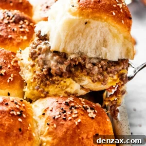 Perfect Cheeseburger Sliders Recipe: Easy, Juicy, Crowd-Pleasing Bites 2 A spatula holding up a sandwich with burger buns filled with ground meat.