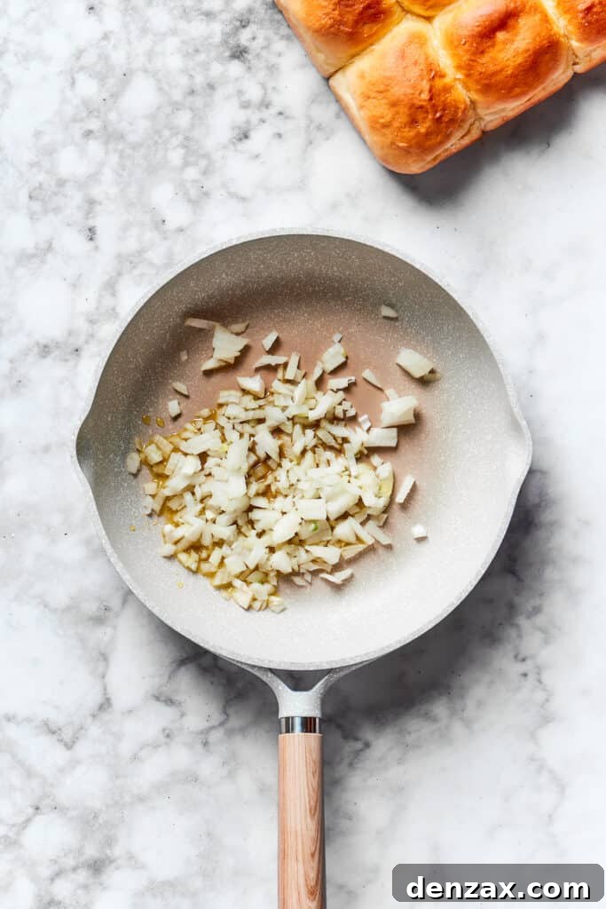 Sauté onions. Chopped onion cooks in a skillet.