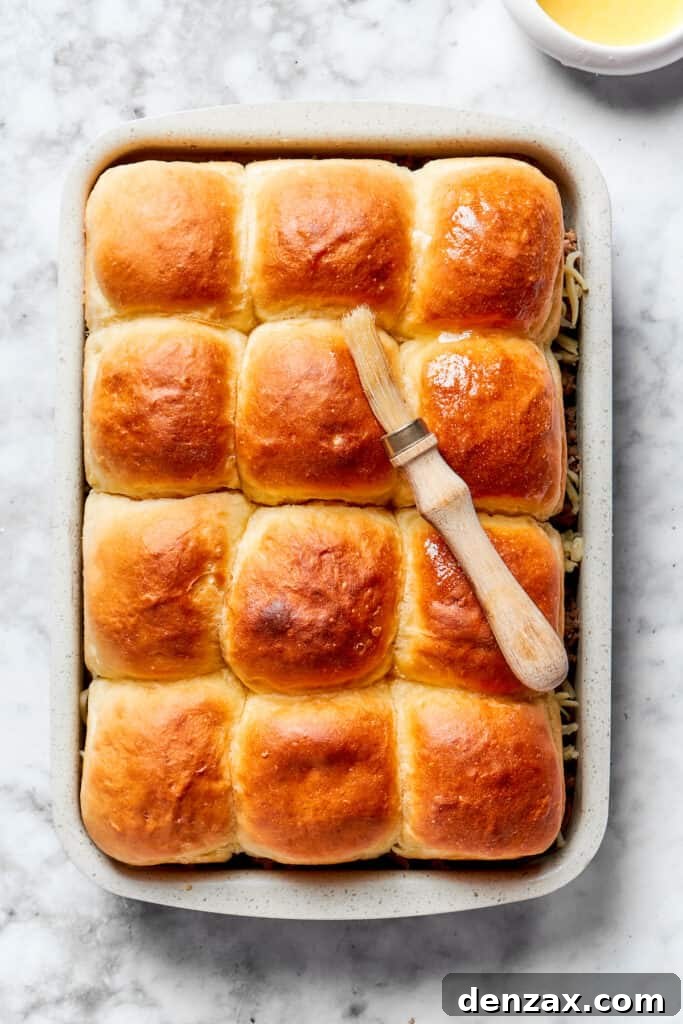 Brush tops with garlic butter. Garlic butter is brushed on top of the rolls.