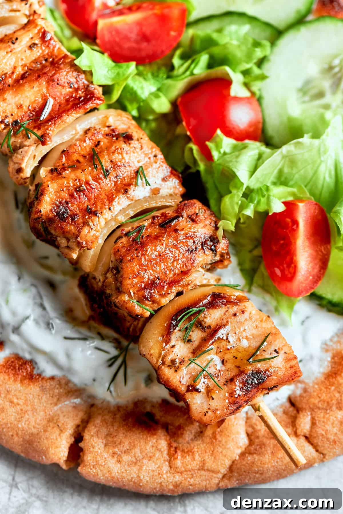 A close up of chicken souvlaki on top of bread.