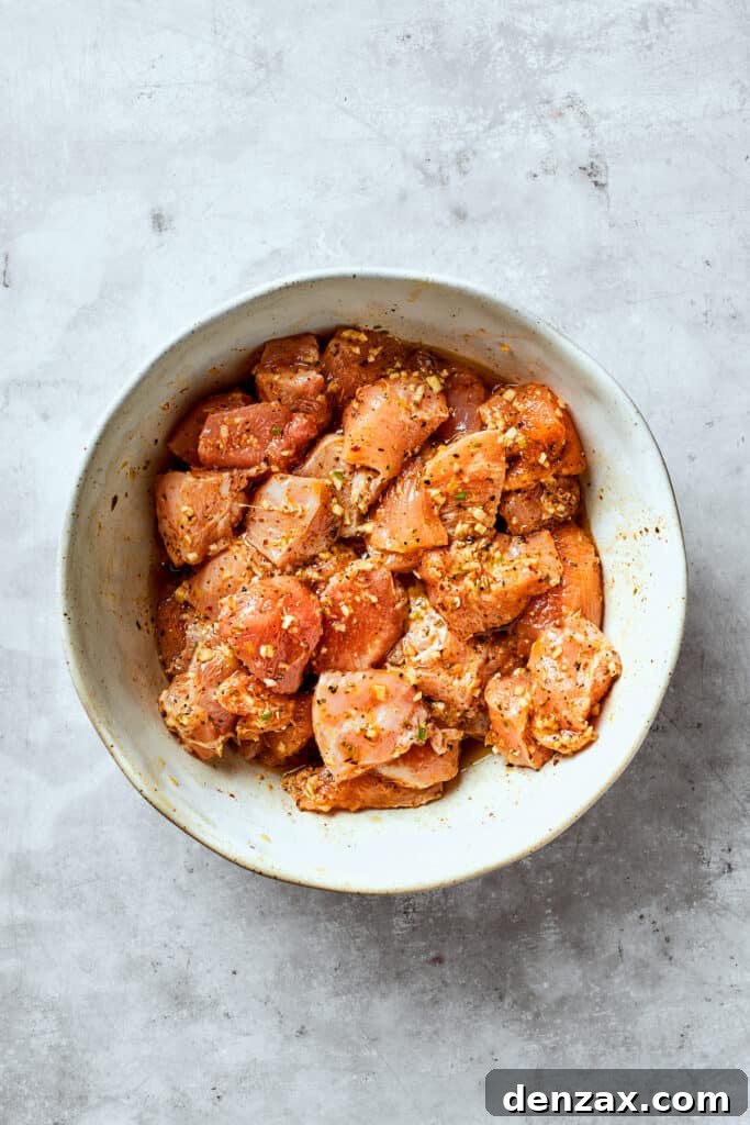 Chicken marinates in a bowl for chicken souvlaki.