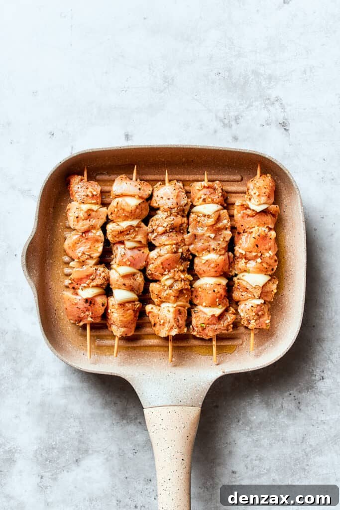 The souvlaki chicken skewers are shown in a grill pan.
