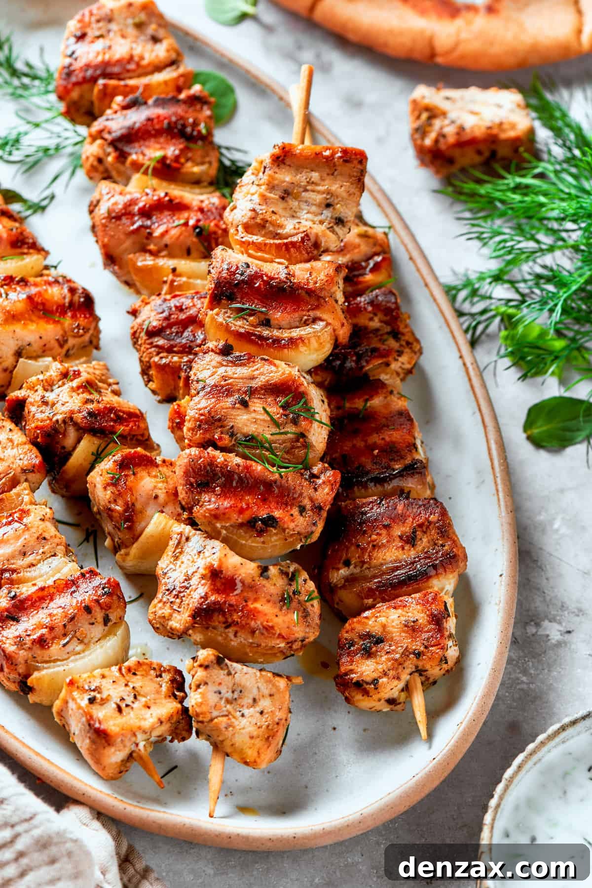 A platter of several skewers of chicken souvlaki.