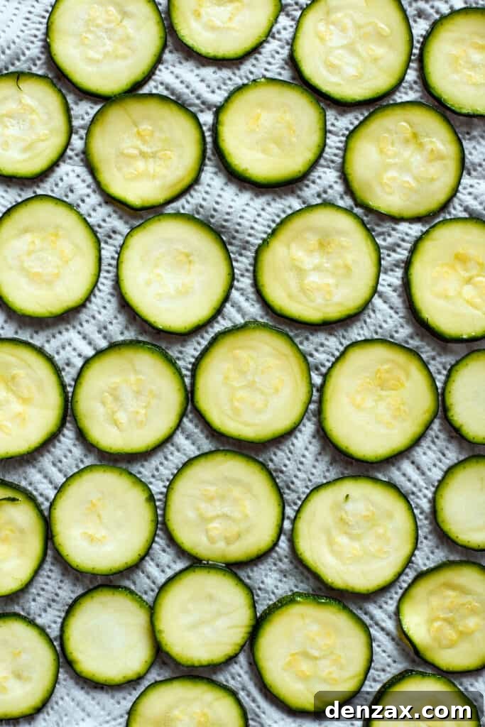 Zucchini slices are arranged on a baking sheet.