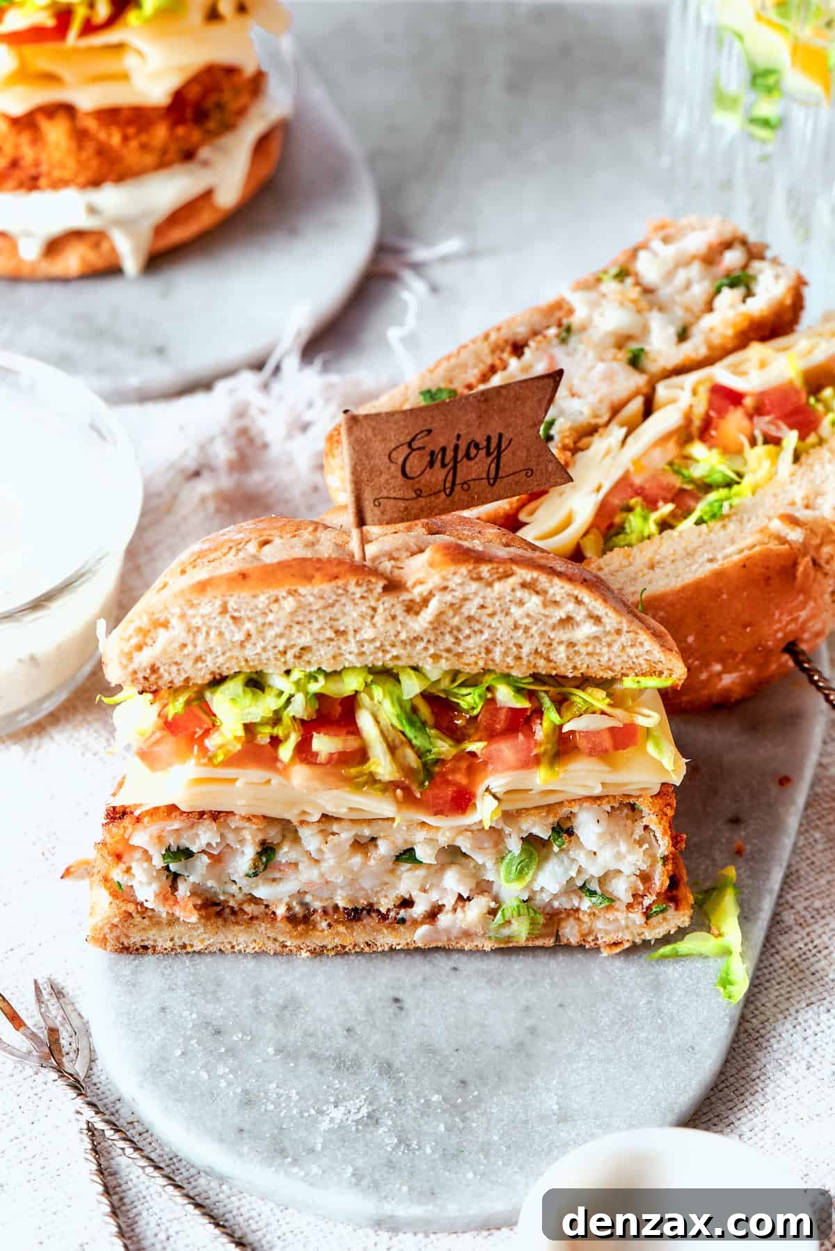 Shrimp burgers are cut in half and served to show their interiors.
