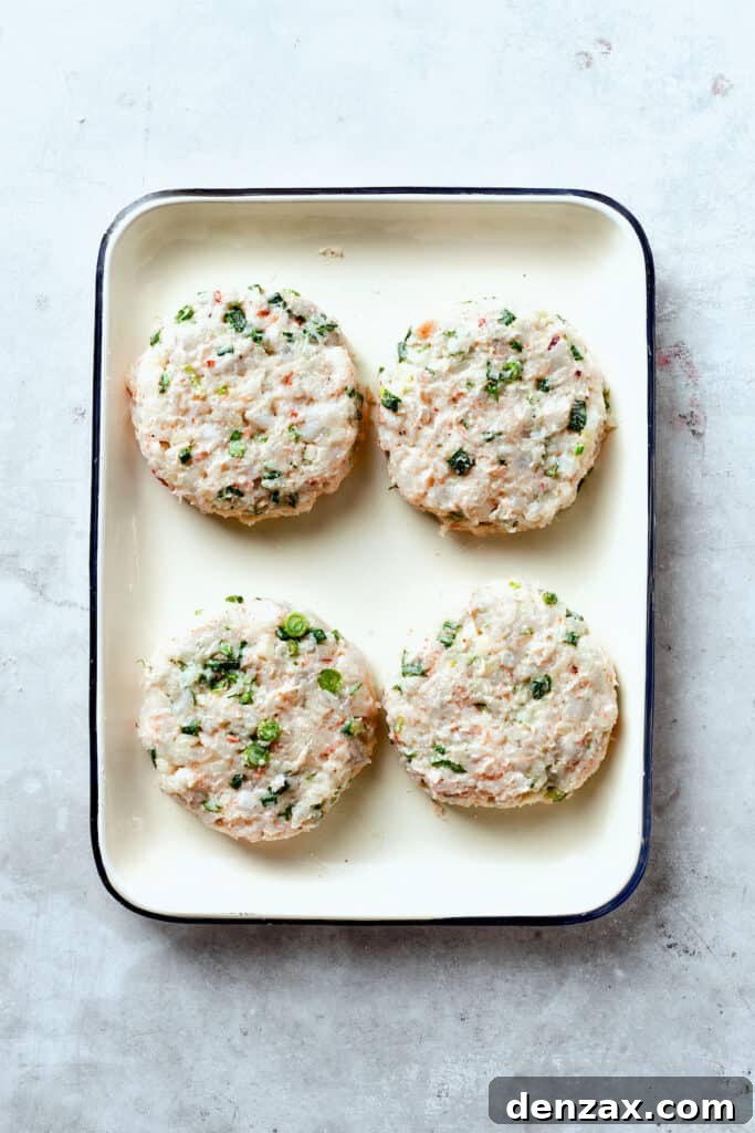 Four formed shrimp patties on a try.