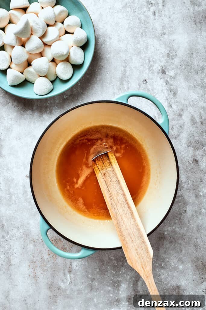 Melt butter and maple syrup A spoon stirs the butter and maple syrup.
