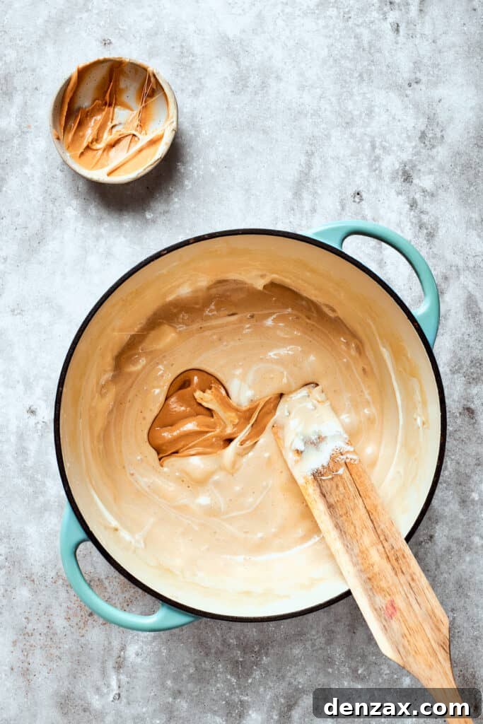 Add peanut butter Peanut butter is stirred into the melted marshmallow mixture.