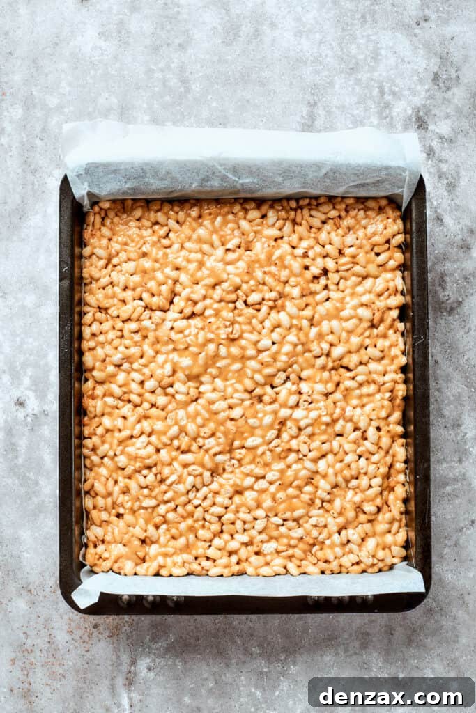 Press into pan The rice crispy treat base is pressed into a pan.
