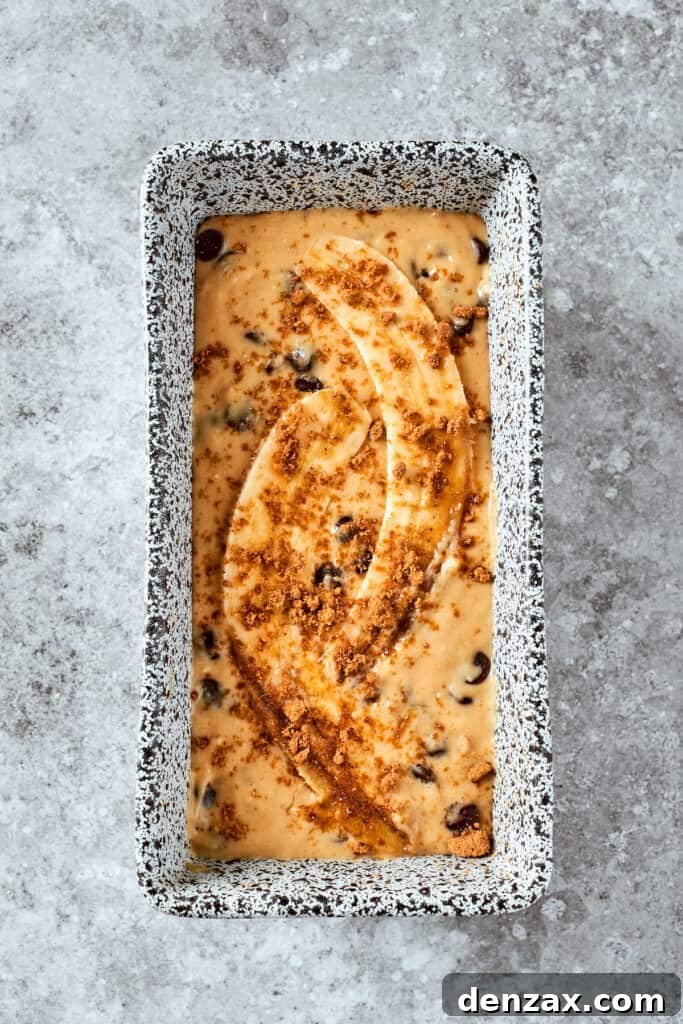 The bread batter is placed in a loaf pan and topped with bananas.