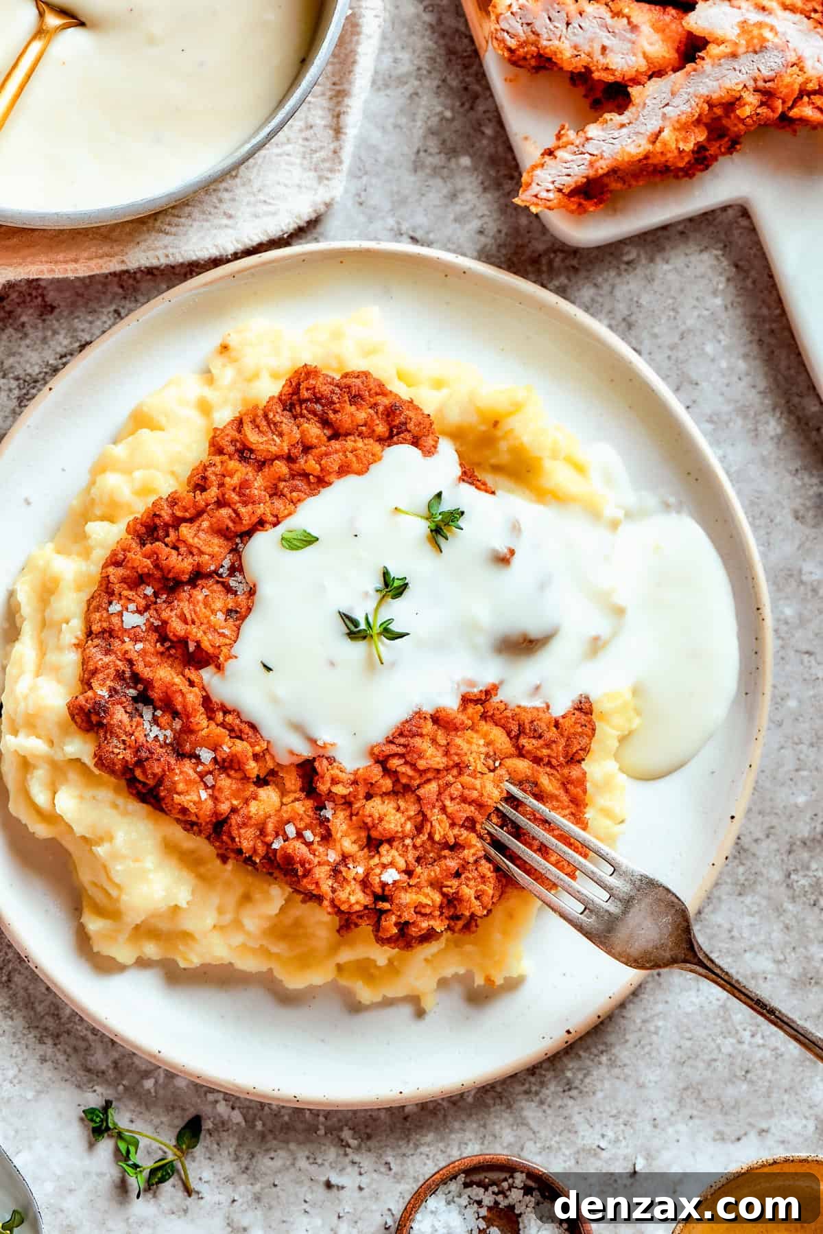 Chicken-fried steak was served over mashed potatoes, and gravy was poured over it.