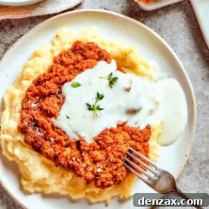 Chicken-fried steak was served over mashed potatoes, and gravy was poured over it.