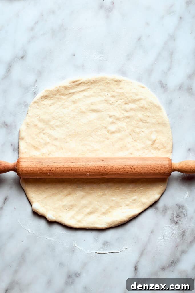 A rolling pin rolls out the pizza dough.