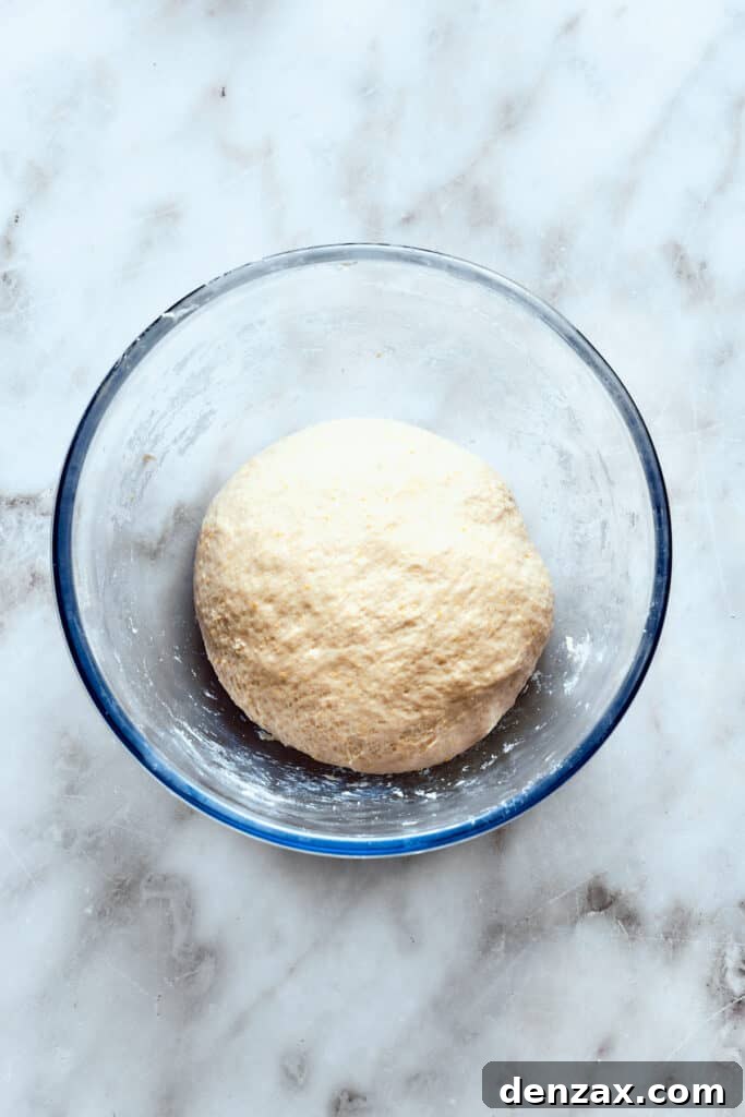A glass bowl holds the pizza dough ball.
