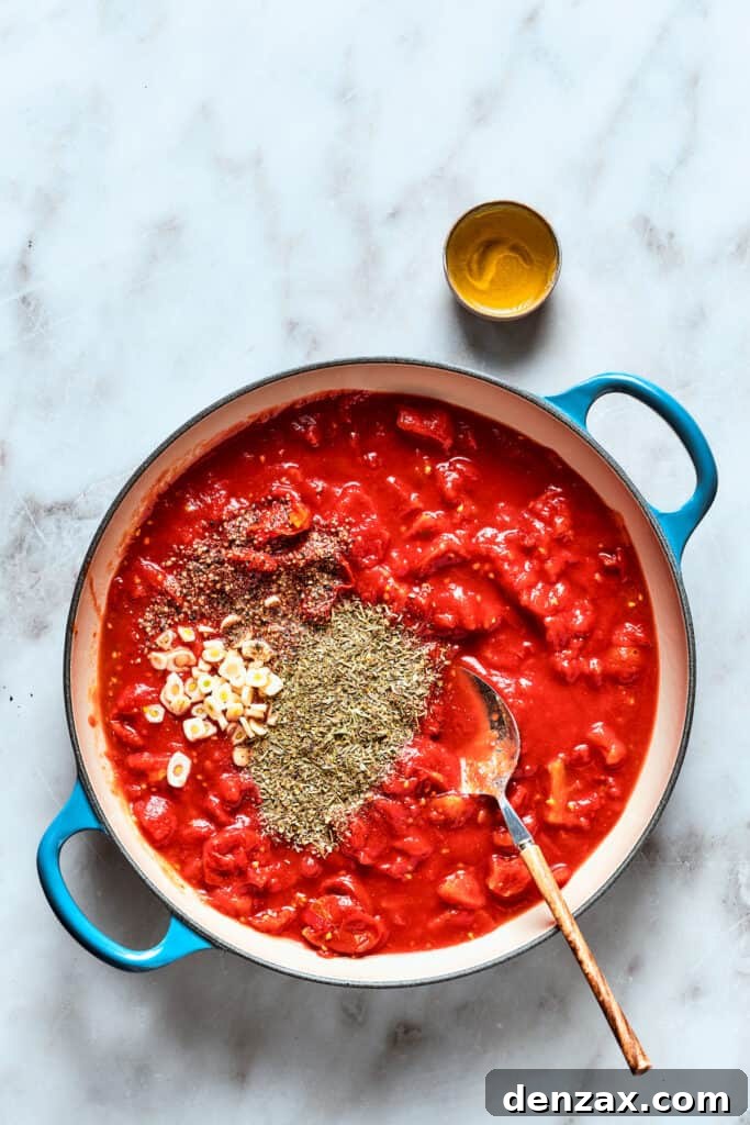 The thick sauce for deep dish pizza is cooked with spices shown on the top.