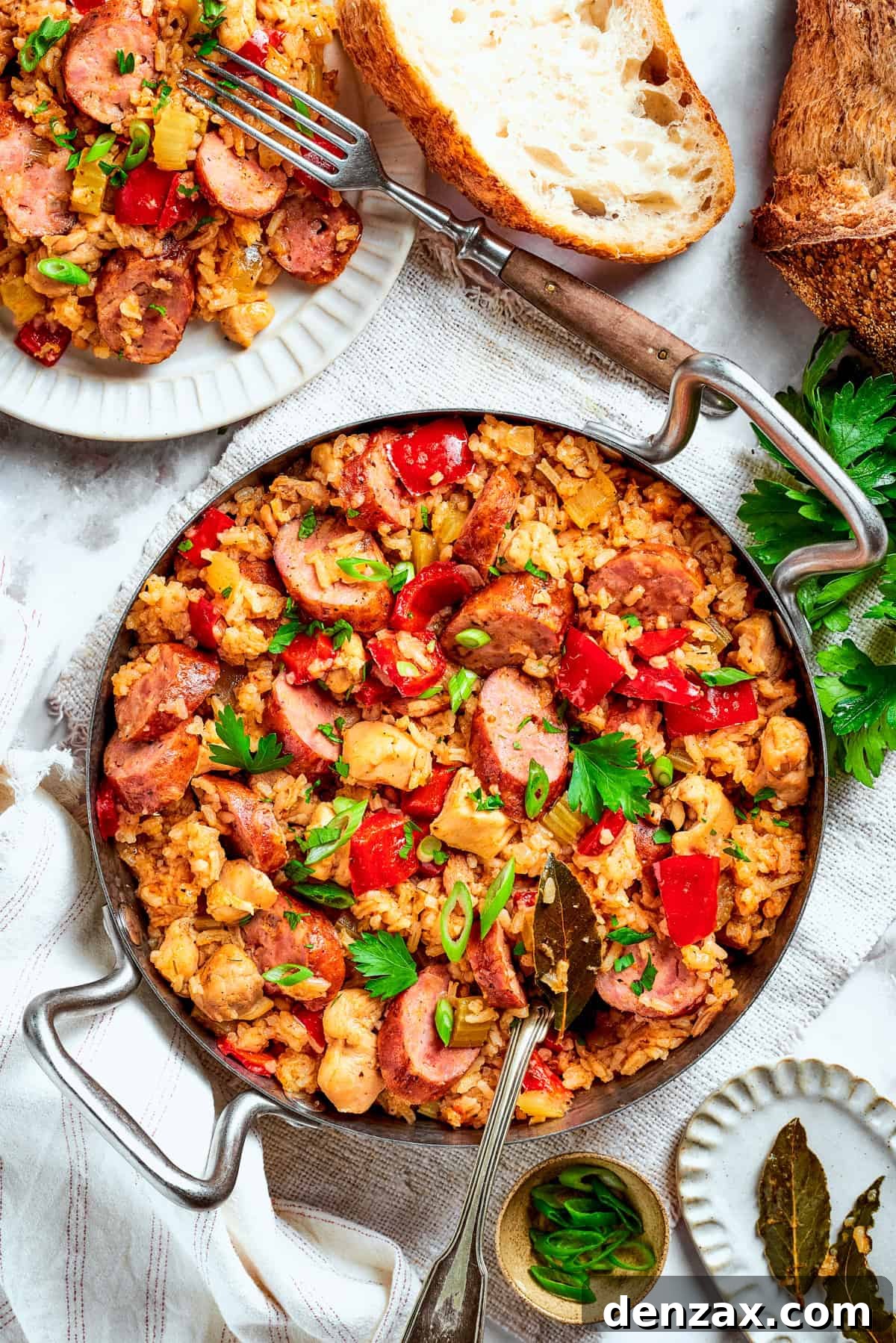 Large pan of jambalaya with bread on the side.