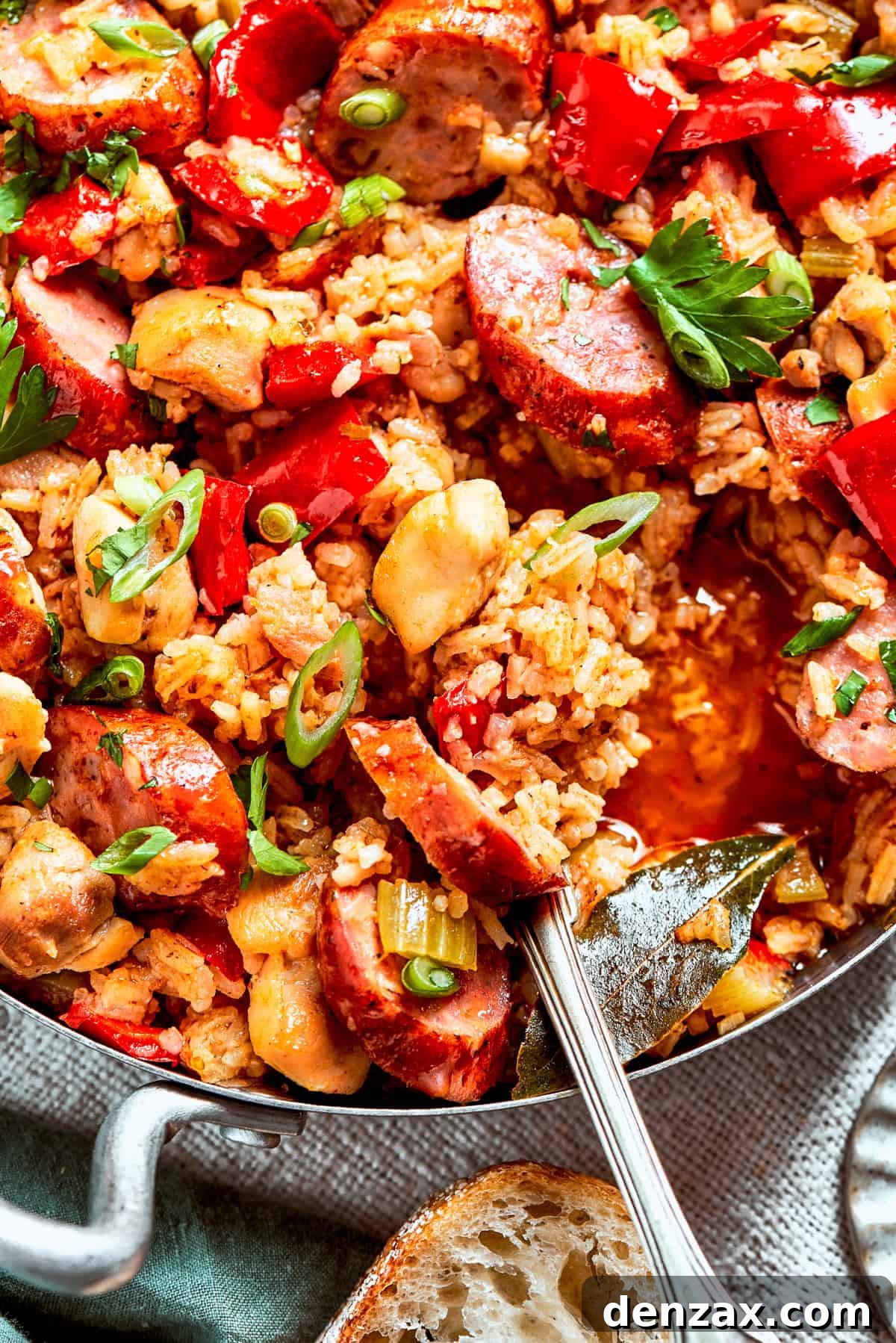 Spoon stirring jambalaya in a pan.