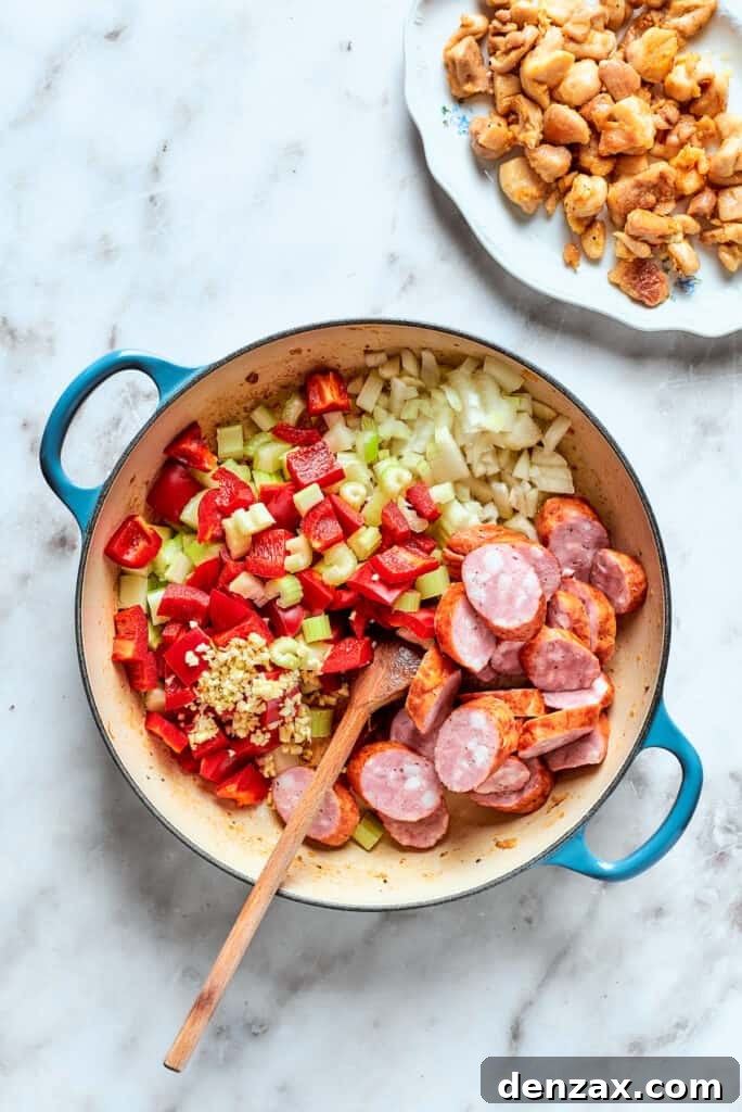 Adding remaining jambalaya ingredients.
