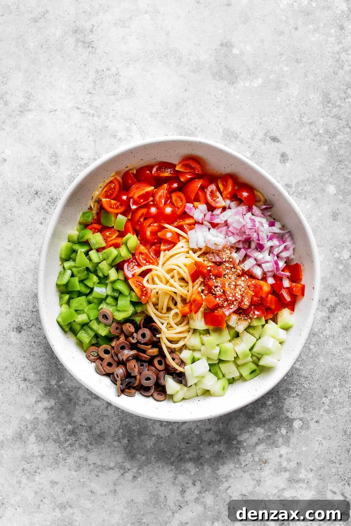 The vegetables are added to the noodles.