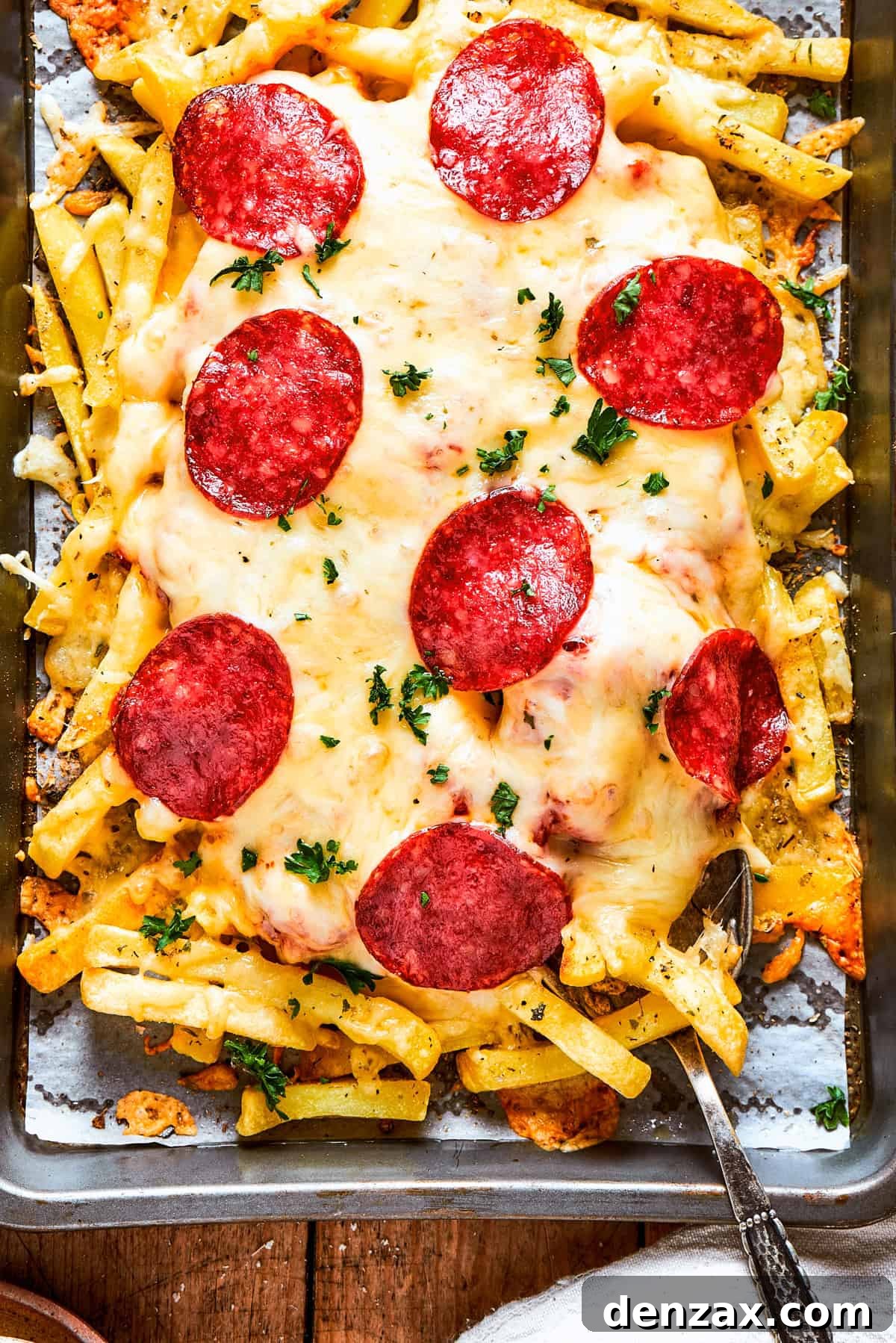 A tray of fries topped with melted cheese and slices of pepperoni.