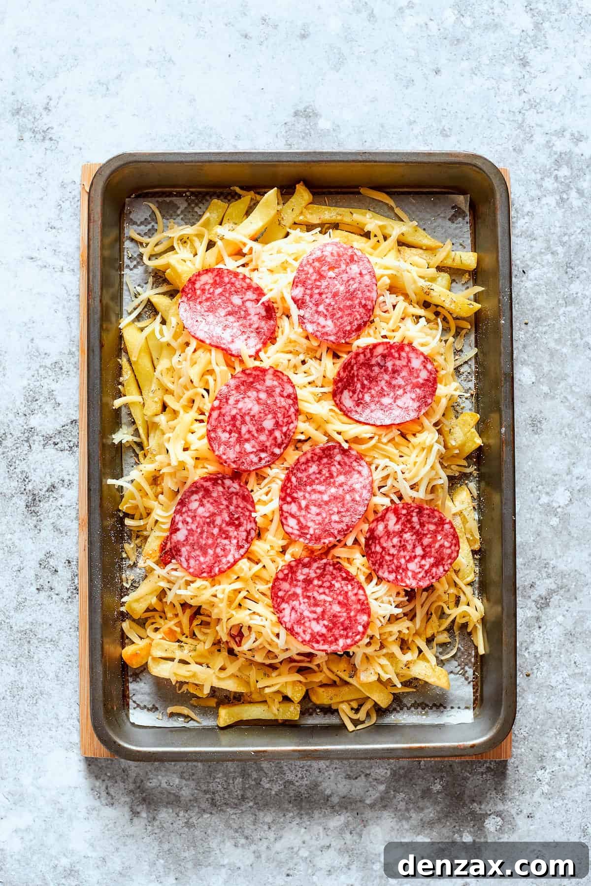 Pepperoni is placed on top of the cheese.