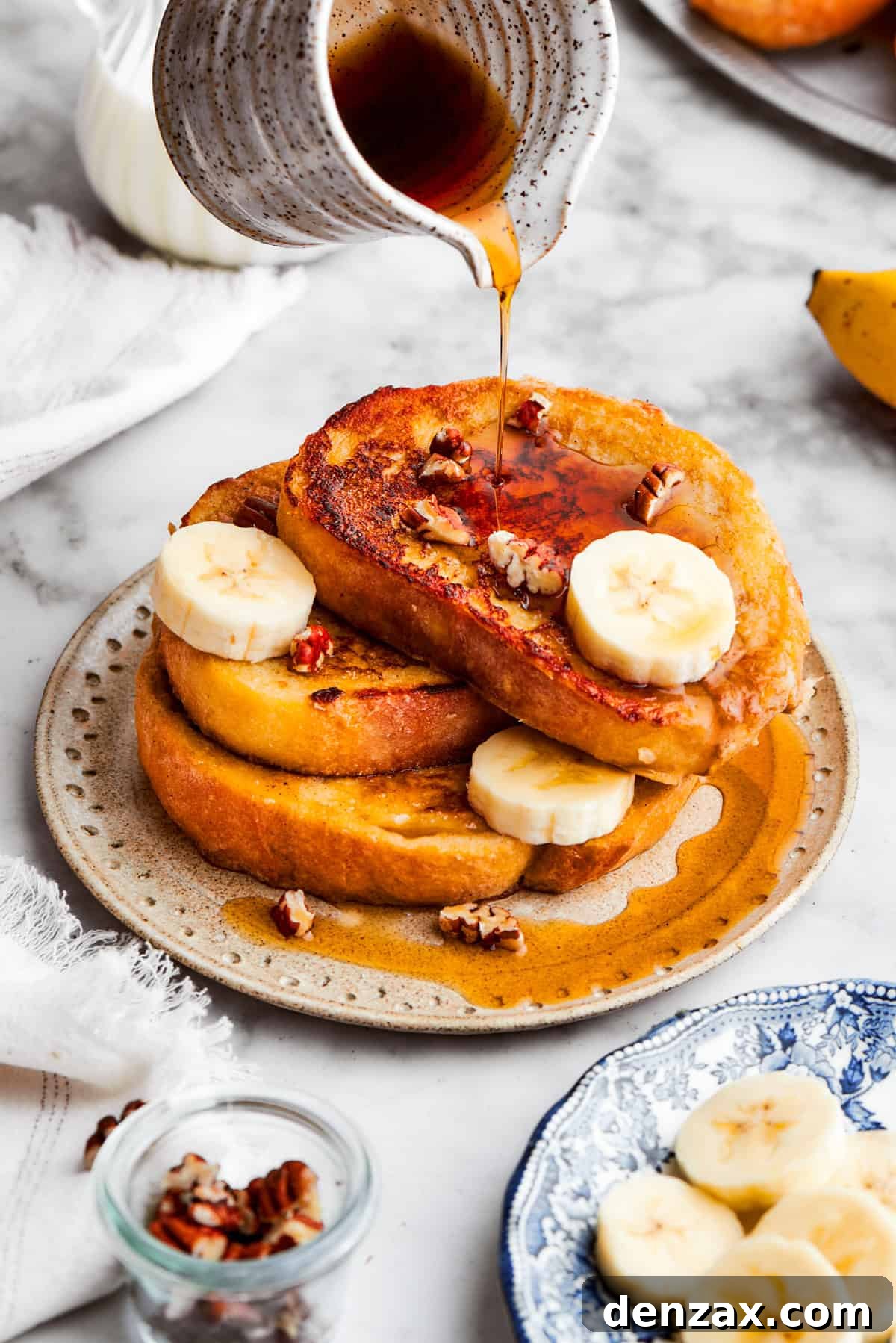 Maple syrup poured over a stack of banana French toast.