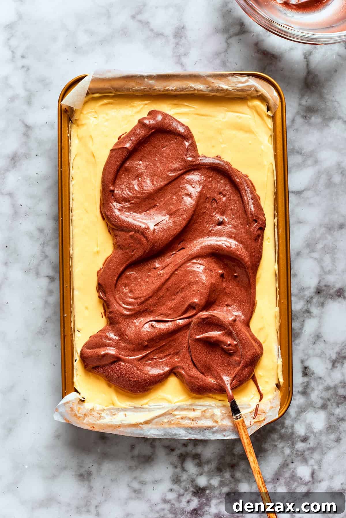 8. Top the vanilla pudding with the chocolate. The chocolate pudding layer is added.