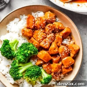 Teriyaki chicken pieces served over rice in a bowl with a side of broccoli.