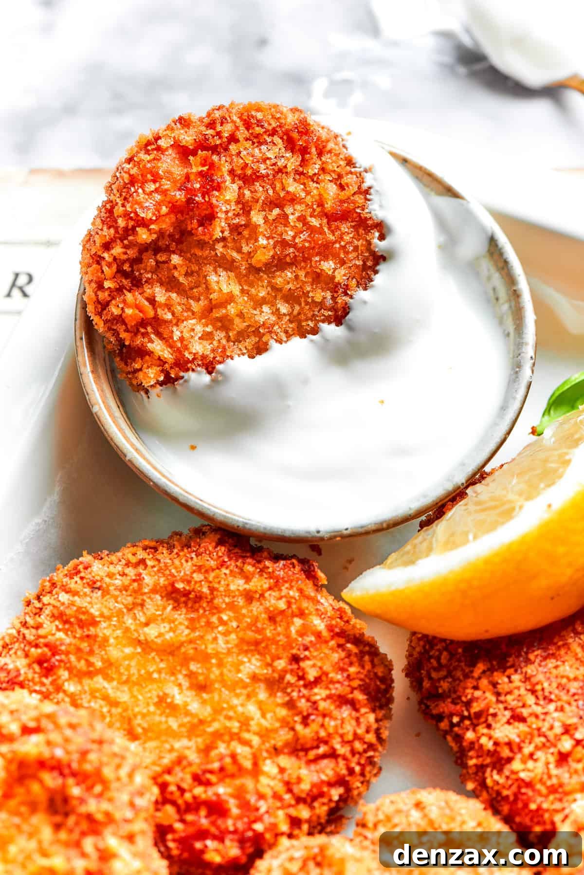 A chicken nugget in a dish of Ranch dip.