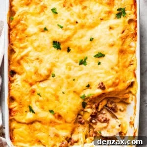 Overhead image of hamburger potato casserole in a baking dish, with a serving of it missing from the corner.