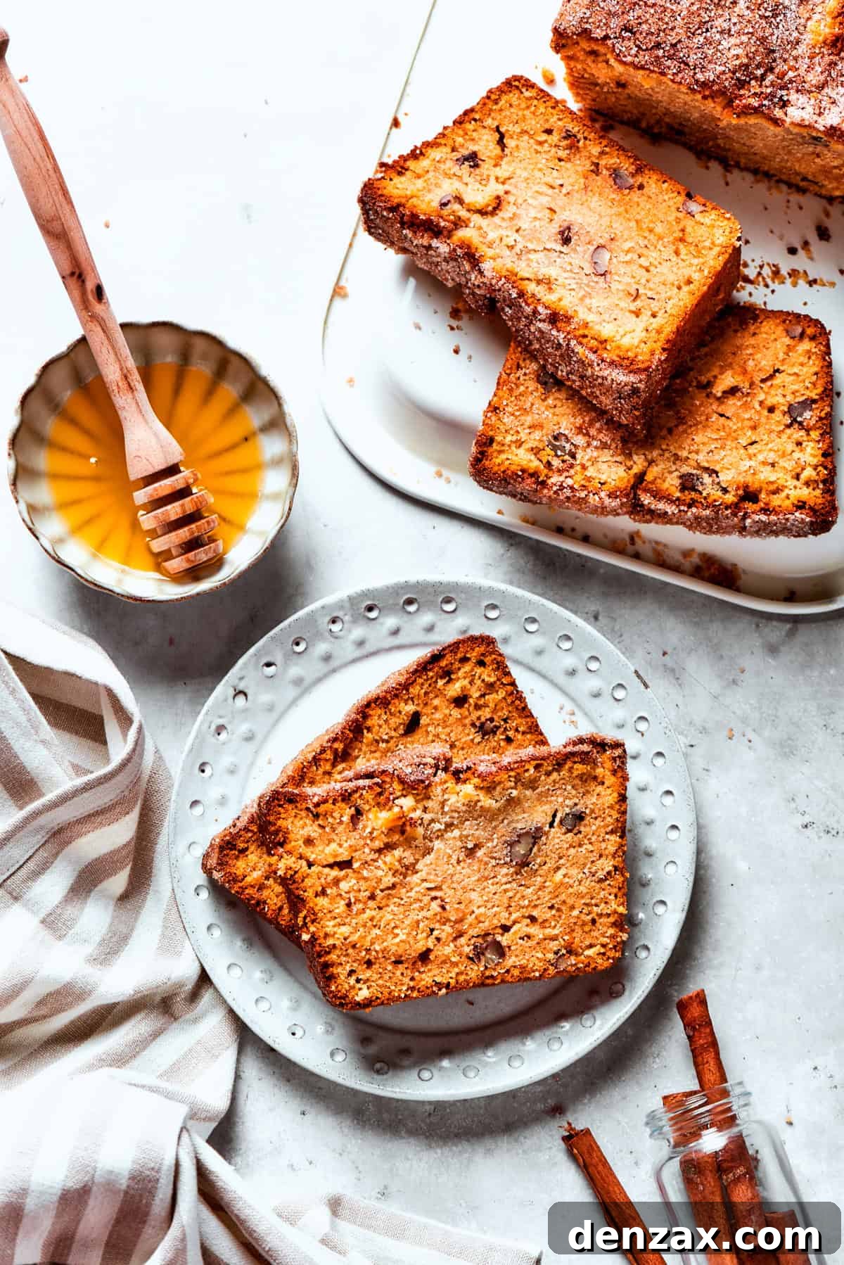 Two slices of Amish bread are served on a plate, with a bowl of honey and more bread set near the plate.
