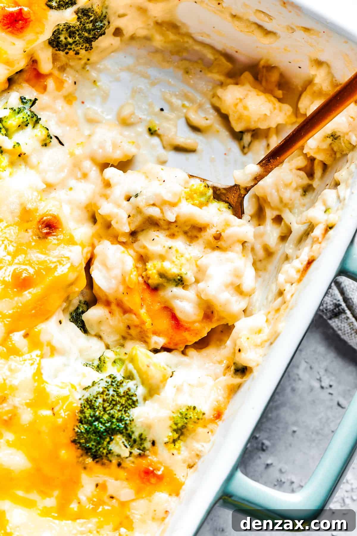 A serving utensil scoops into a pan of broccoli & rice casserole.