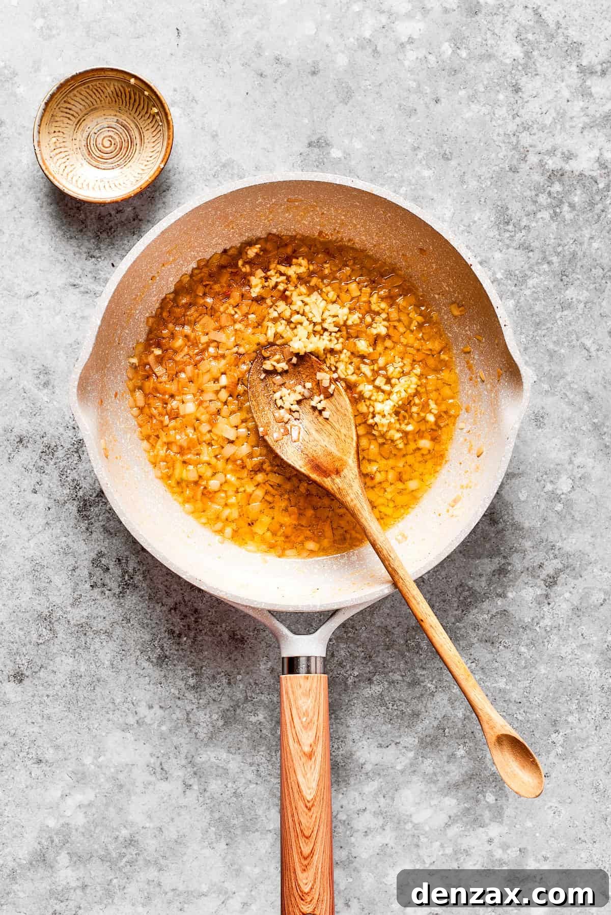 Garlic and shallot added to a pan.