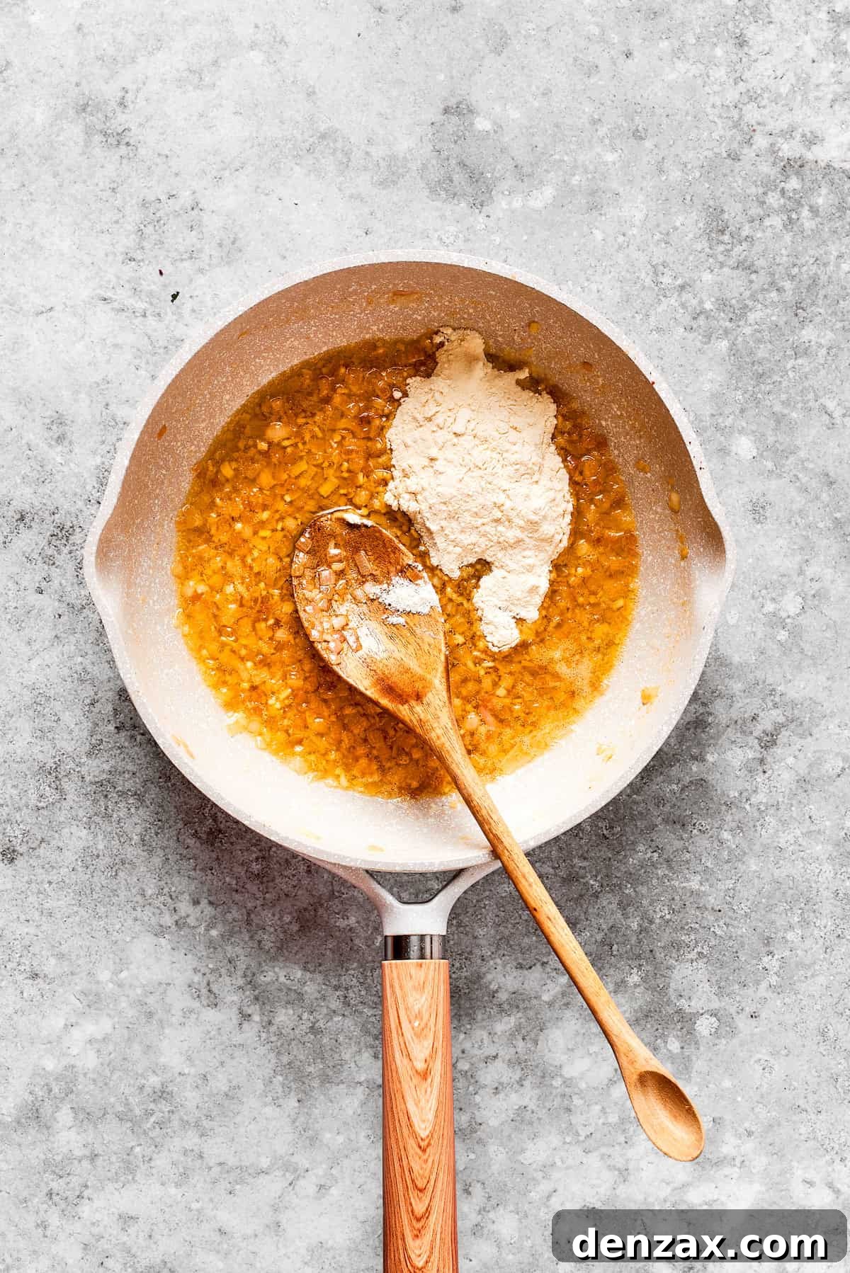 Flour is added to a pan.