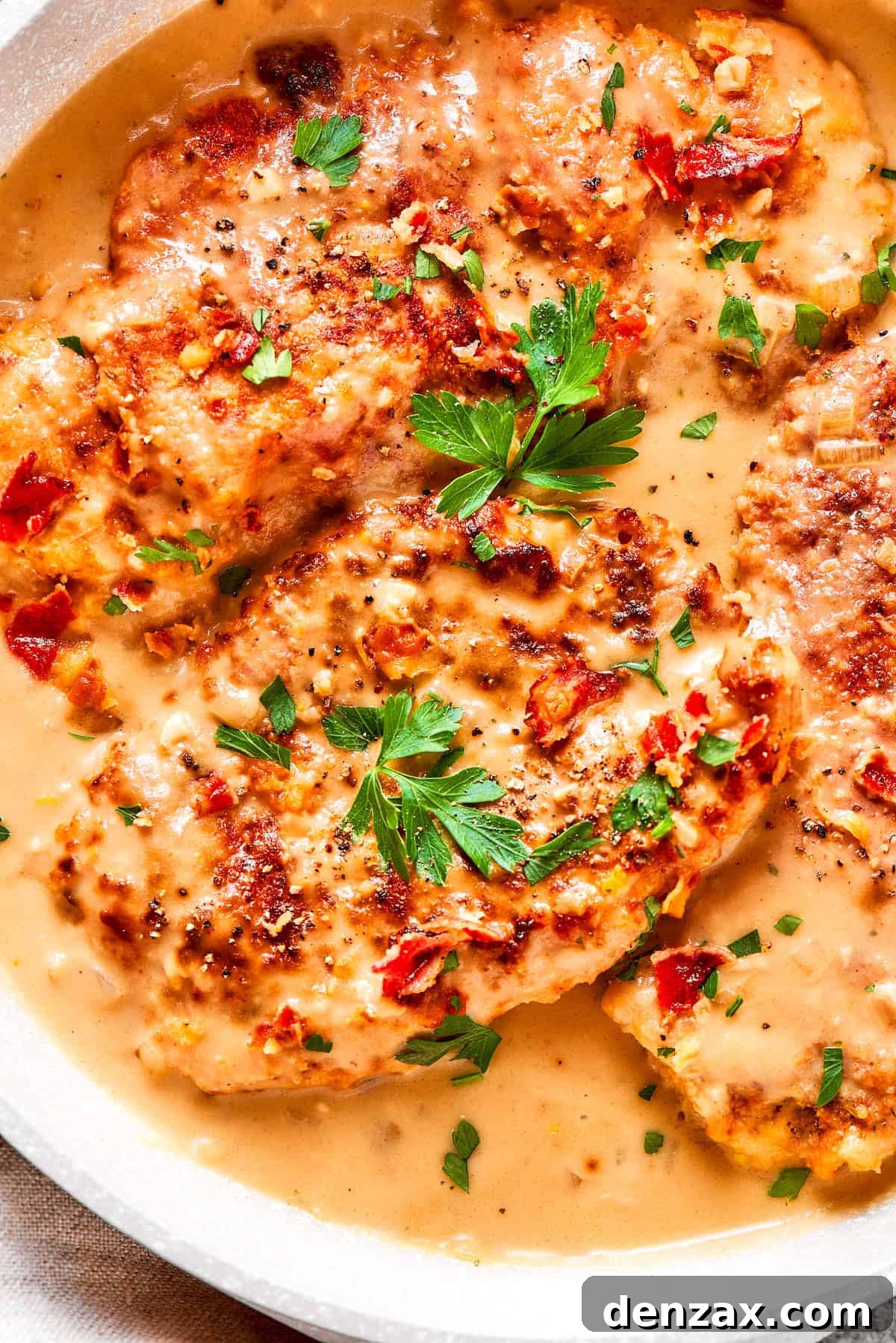 Parsley tops pieces of smothered chicken.