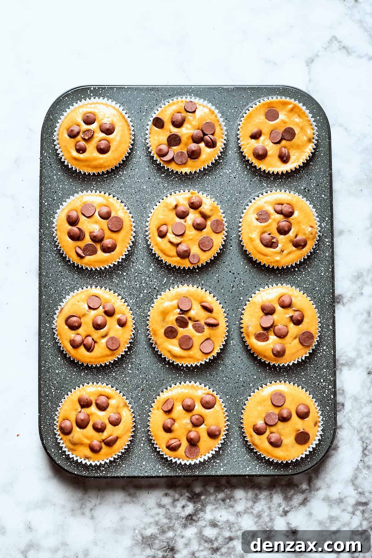 Warmly spiced Pumpkin Chocolate Chip Muffins are soft, fluffy, and loaded with chocolate chips in every bite! Pumpkin chocolate chip muffin batter in a muffin tin.