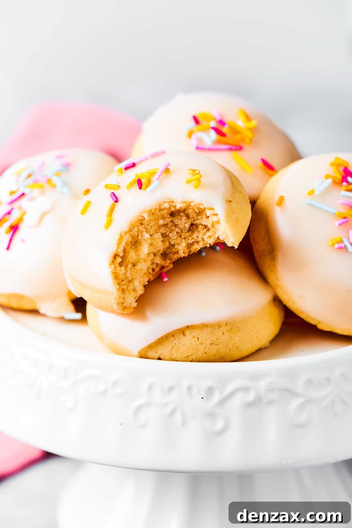 Anginetti cookies arranged on a white cake stand.