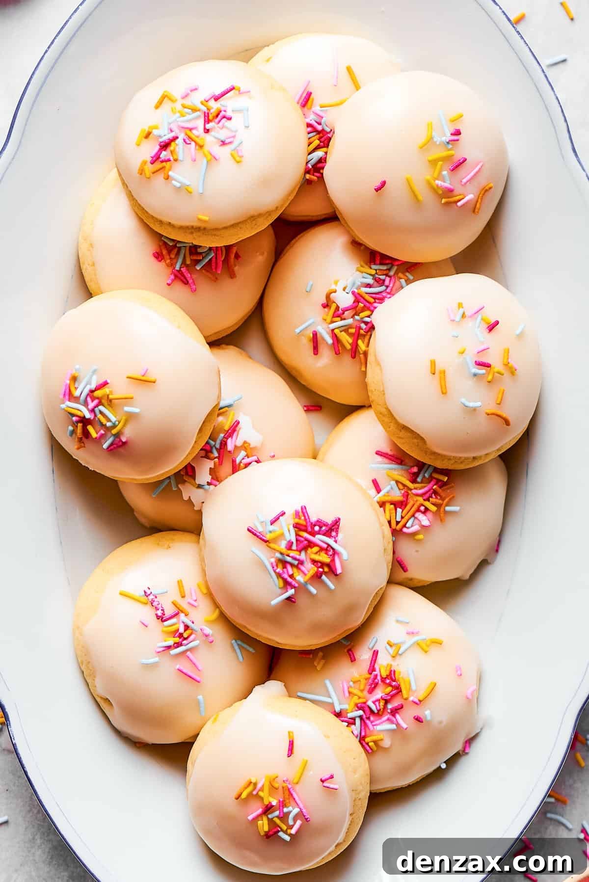 Sprinkles top anginetti cookies arranged on a plate.