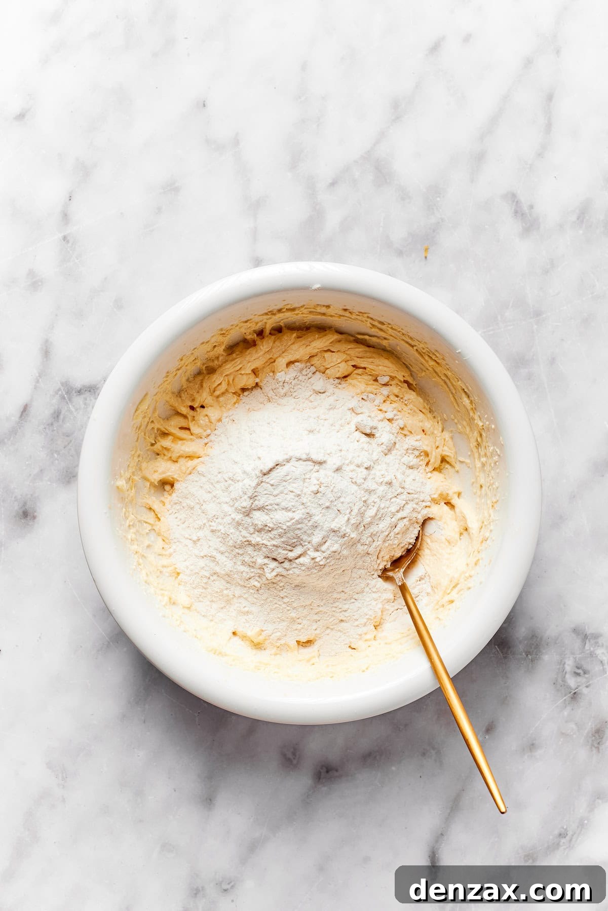 Flour is stirred into a bowl of anginetti cookie dough.